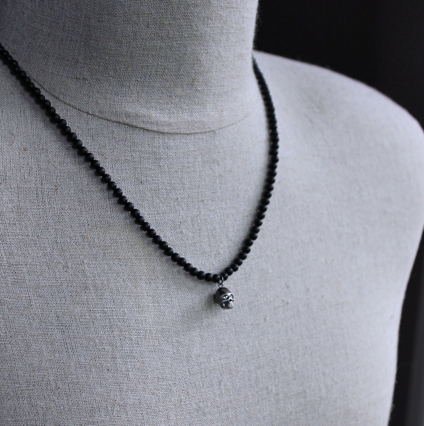 matte black bead necklace with small skull pendant