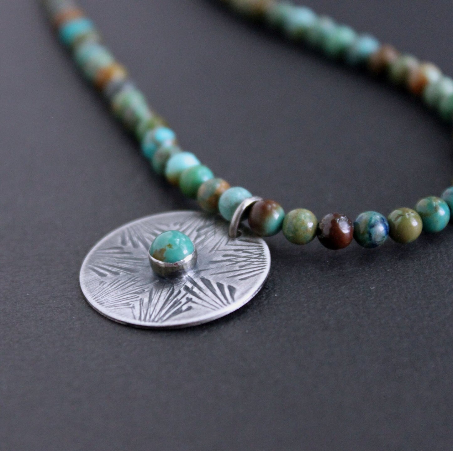 hand stamped silver pendant on turquoise bead necklace