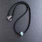 Black beaded necklace with a turquoise stone 
